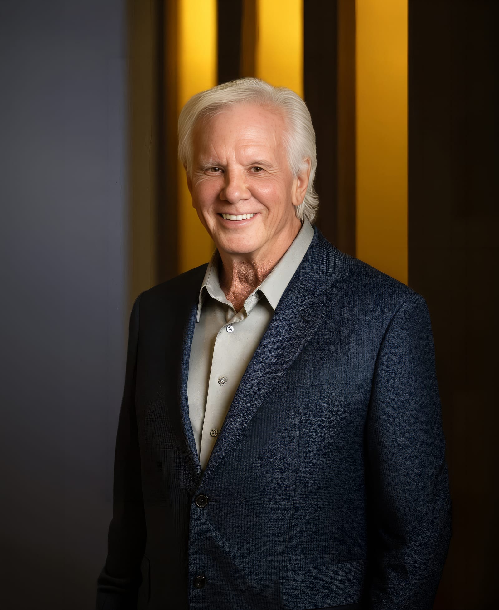 Dr. R. Scott Yarish smiling, in a navy blazer and an open-collar grey shirt