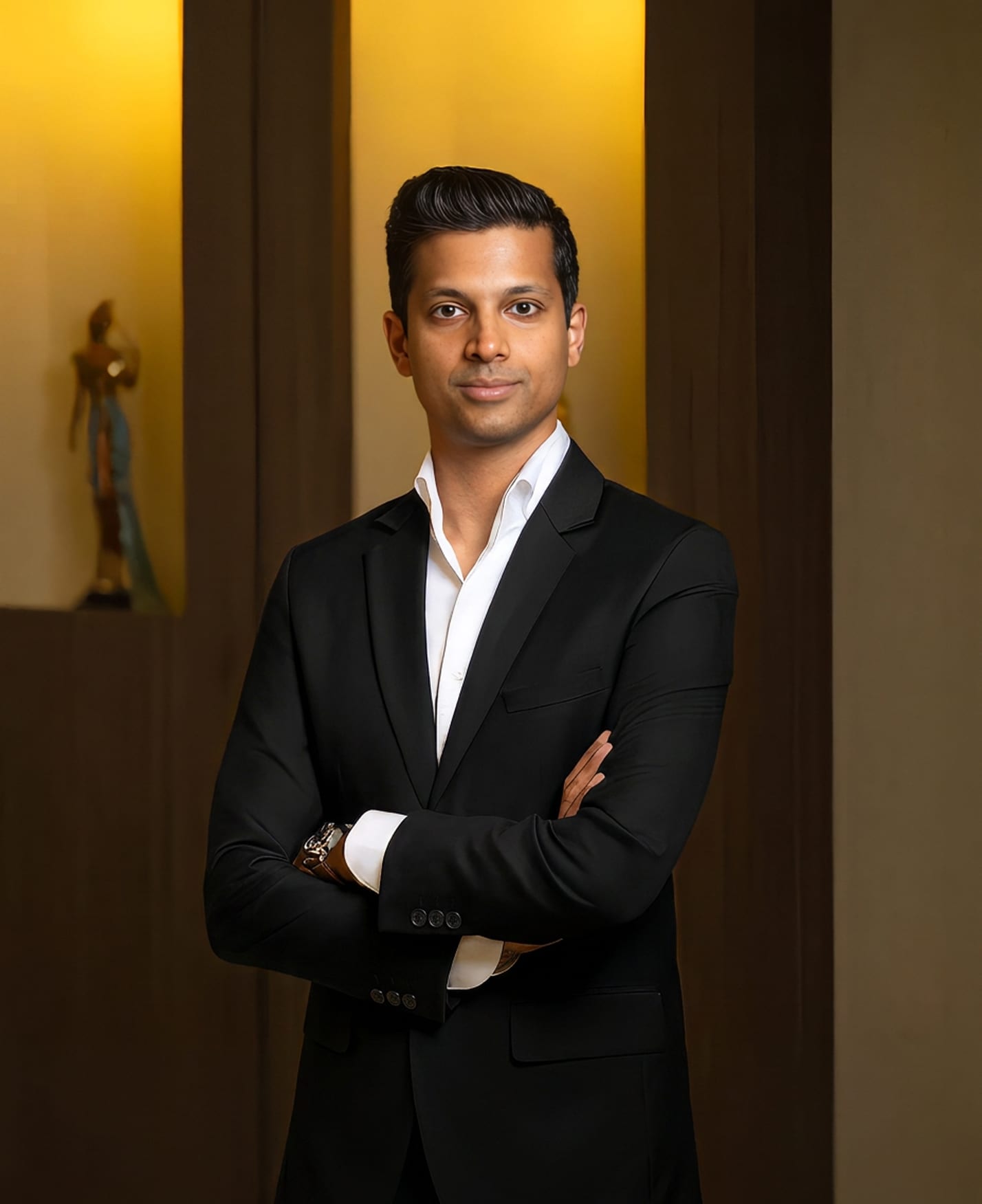 Dr. Janak Parikh, plastic surgeon, standing with his arms crossed